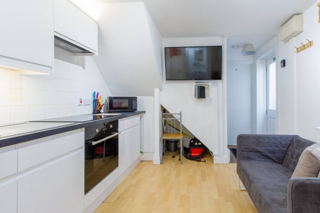 Kitchen area with a TV and sofa in 5 St Pauls Lane, Cheltenham.