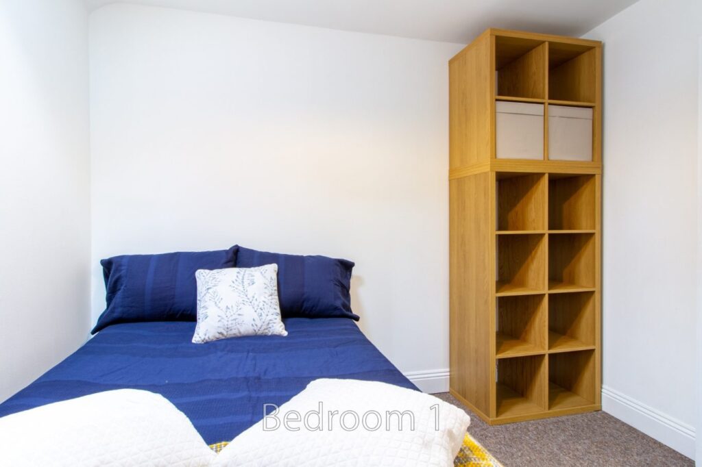 Bright bedroom with storage shelves in Bedroom 1 at 5 St Pauls Lane, Cheltenham.